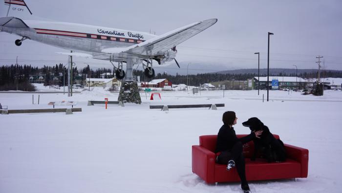 Janna et son chien Howard Benjamin sur le sofa rouge.